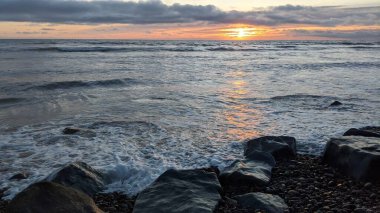Swamis Sahili 'nde Sunset Sky. Güney Kaliforniya 'nın ücra kumsalları, gün batımları, sörfçüler, gelgit havuzları, dalgalar yontulmuş kayalar, palmiye ağaçları ve San Diego' nun 25 mil kuzeyindeki Encinitas Kayalık Sörf Parkı 'nda şiddetli kış fırtınaları..