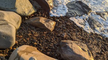 Swamis Sahili 'nin erimiş kayaları sanatı. 50 yıl önce kıyı boyunca uzanan erozyon kontrol kayaları Swamis Resif Parkı Encinitas California 'daki çok renkli nehir kayalarıyla çevrili..