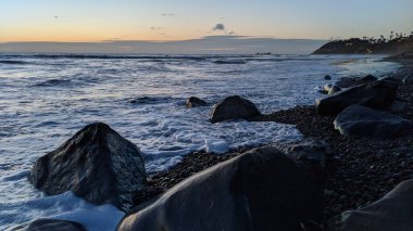 Swamis Sahili 'nin Erimiş Kayalıkları. 50 yıl önce, Swamis Resif Parkı Encinitas 'taki sörf karışımında eski nehir kayaları tarafından çevrelenmiş erozyon kontrol kayaları kıyıya bırakıldı..