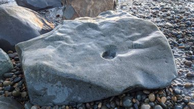 Swamis Sahili 'nde serin renkli River Rocks karışımı. Antik çağlarda hızla yuvarlanan ve parlatılan bu yuvarlak kayalar, Swamis Resif Sörf Parkı Encinitas California 'daki erimiş kayaların heykel ve pürüzsüzleştirilmesine yardımcı oldu..