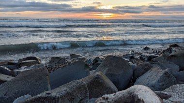 Southern California beach scenes north of San Diego - Sunsets, surfers, tide pools, waves, rocks, sand and palms trees at Cardiff Reef Beach Park in Encinitas California. clipart