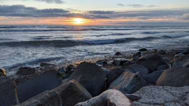 Swamis Sahili 'nde Sunset Sky' dan sonra. Güney Kaliforniya 'nın ücra kumsalları, gün batımları, sörfçüler, gelgit havuzları, dalgalar yontulmuş kayalar, palmiye ağaçları ve San Diego' nun 25 mil kuzeyindeki Encinitas Kayalık Sörf Parkı 'nda şiddetli kış fırtınaları..