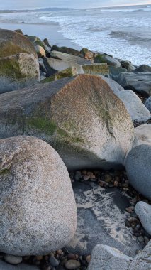 Swamis Sahili 'nde Sunset Sky' dan sonra. Güney Kaliforniya 'nın ücra kumsalları, gün batımları, sörfçüler, gelgit havuzları, dalgalar yontulmuş kayalar, palmiye ağaçları ve San Diego' nun 25 mil kuzeyindeki Encinitas Kayalık Sörf Parkı 'nda şiddetli kış fırtınaları..