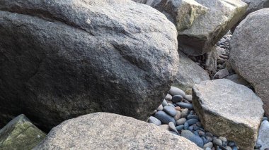 The Cool Colored Mix of River Rocks at Swamis Beach. Rounded and polished from tumbling in ancient fast moving inland streams and ocean waves these round rocks helped sculpture the Melted Rocks at Cardiff and Swamis Reef Parks Encinitas California. clipart