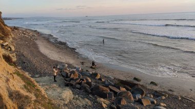 Güney Kaliforniya kıyıları - dalgalar, plajlar, gün batımları ve siluetler, gelgit havuzları, sörfçüler, palmiye ağaçları ve Encinitas 'taki Cardiff Sahili Sörf Parkı' ndaki serin kaya soyutları.