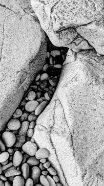 Swamis Sahili 'nin soğuk erimiş kayaları. 50 yıl önce, Swamis Resif Parkı Encinitas 'taki Swamis Sörf Parkı Encinitas' ta sörf yapan kayalar tarafından çevrelenmiş eski nehir kayalarıyla çevrelenmiş erozyon kontrol kayaları..