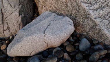 Swamis Sahili 'ndeki River Rocks' un çok renkli karışımı. Yuvarlak ve cilalı antik hızlı akıntılar ve sonra okyanus dalgaları bu yuvarlak kayalar erimiş kayaların Swamis Resif Sörf Parkı Encinitas California 'da pürüzsüz olmasına yardımcı oldu..