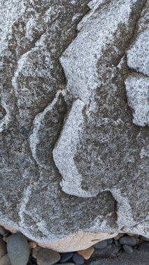 Swamis Sahili 'nin soğuk erimiş kayaları. 50 yıl önce kıyı şeridi boyunca uzanan okyanus dalgası erozyon kontrol taşları şimdi Swamis Resif Sörf Parkı Encinitas California 'daki antik nehir kayalarıyla çevrili soyut heykellere benziyor..