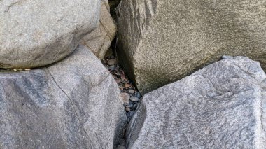Swamis Sahili 'nin erimiş kayaları sanatı. 50 yıl önce kıyıya bırakılan erozyon kontrol kayaları şu anda çok renkli nehir kayalarıyla çevrili. Swamis Resif Sörf Parkı Encinitas California 'da tüm okyanus dalgaları parlıyor..