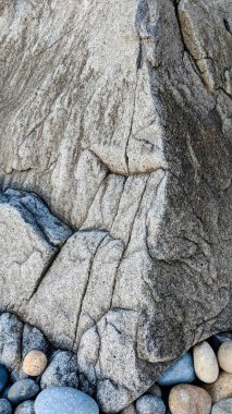 River Rocks and the radically cool Melted Rocks of Swamis Beach. Erosion control boulders put down along the shore 50 years ago surrounded by ancient river rocks all in the surf mix at Swamis Reef Surf Park Encinitas California. clipart