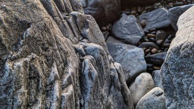 Swamis Sahili 'nin Kayalıkları. Hızla akan akarsular ve okyanus dalgaları sayesinde yuvarlanan ve parlatılan birçok volkanik kökenli nehir kayaları şimdi Swamis Sörf Parkı sahil Encinitas California 'da bir arada..
