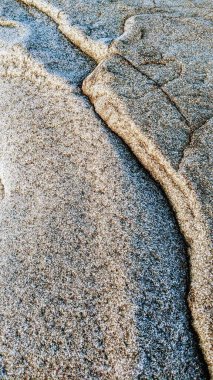 The cool Melted Rocks of Swamis Beach. Erosion control quarry rock boulders put down along the shore 50 years ago now worn resembling fine sculptures surrounded by ancient river rocks all in the surf mix at Swamis Reef Surf Park Encinitas California. clipart