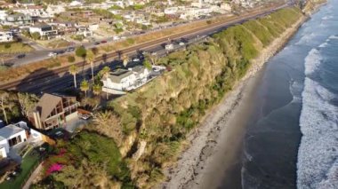 Günbatımı siluetleri, sörfçüleri, gelgit havuzları ve palmiye ağaçlarıyla Encinitas California 'daki Swamis Resif Sörf Parkı' nda güneşli Güney Kaliforniya sahneleri..