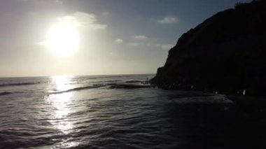 Günbatımı siluetleri, sörfçüleri, gelgit havuzları ve palmiye ağaçlarıyla Encinitas California 'daki Swamis Resif Sörf Parkı' nda güneşli Güney Kaliforniya sahneleri..