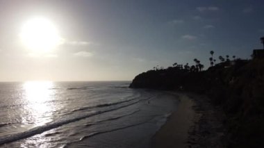 Günbatımı siluetleri, sörfçüleri, gelgit havuzları ve palmiye ağaçlarıyla Encinitas California 'daki Swamis Resif Sörf Parkı' nda güneşli Güney Kaliforniya sahneleri..
