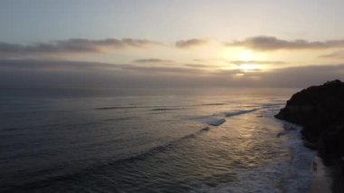 Günbatımı siluetleri, sörfçüleri, gelgit havuzları ve palmiye ağaçlarıyla Encinitas California 'daki Swamis Resif Sörf Parkı' nda güneşli Güney Kaliforniya sahneleri..