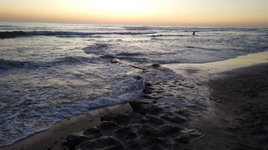 Swamis Sahili 'ndeki Nehir Kayalarının Serin Renkli Karışımı. Antik çağlarda hızla yuvarlanıp parlayan bu yuvarlak kayalar Swamis Resif Sörf Parkı Encinitas California 'daki erimiş kayaların heykelini yaptı..