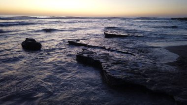 Southern California beach and shore scenes with silhouettes, surfers, tide pools and palms trees at Cardiff By The Sea beach in Encinitas California. clipart