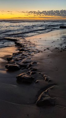 Güney Kaliforniya 'da tenha plajlar, gün batımları, sörfçüler, gelgit havuzları, palmiye ağaçları ve Encinitas Kaliforniya' daki Swamis Resif Sörf Parkı 'ndaki kaya soyutlamaları.