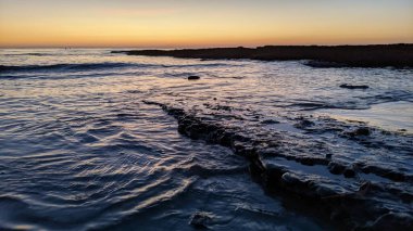 Günbatımında Güney Kaliforniya sahillerinde, eski resif gel-git havuzları, okyanus dalgaları ve Swamis Resif Parkı Encinitas California 'da alacakaranlık renkli gökyüzü.