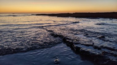 Günbatımında Güney Kaliforniya sahillerinde, eski resif gel-git havuzları, okyanus dalgaları ve Swamis Resif Parkı Encinitas California 'da alacakaranlık renkli gökyüzü.