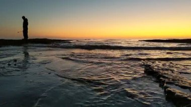 Günbatımında Güney Kaliforniya sahillerinde, eski resif gelgitleri, okyanus dalgaları ve karanlık gökyüzü Swamis Resif Parkı Encinitas California 'da..