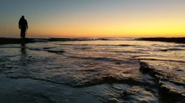 Günbatımında Güney Kaliforniya sahillerinde, eski resif gelgitleri, okyanus dalgaları ve karanlık gökyüzü Swamis Resif Parkı Encinitas California 'da..