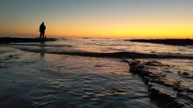 Günbatımında Güney Kaliforniya sahillerinde, eski resif gelgitleri, okyanus dalgaları ve karanlık gökyüzü Swamis Resif Parkı Encinitas California 'da..
