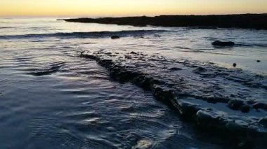 Günbatımında Güney Kaliforniya sahillerinde, eski resif gelgitleri, okyanus dalgaları ve karanlık gökyüzü Swamis Resif Parkı Encinitas California 'da..