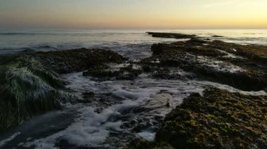 Günbatımında Güney Kaliforniya sahillerinde, eski resif gelgitleri, okyanus dalgaları ve karanlık gökyüzü Swamis Resif Parkı Encinitas California 'da..