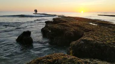 Günbatımında Güney Kaliforniya sahillerinde, eski resif gelgitleri, okyanus dalgaları ve karanlık gökyüzü Swamis Resif Parkı Encinitas California 'da..