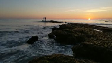 Günbatımında Güney Kaliforniya sahillerinde, eski resif gelgitleri, okyanus dalgaları ve karanlık gökyüzü Swamis Resif Parkı Encinitas California 'da..