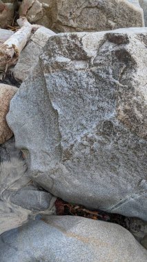 Swamis Sahili 'nin sanatsal erimiş kayaları. 50 yıl önce kıyı boyunca uzanan erozyon kontrol kayaları Swamis Resif Sörf Parkı Encinitas California 'daki dalga enerjili kaya parlatıcı ekibindeki çok renkli nehir kayalarıyla çevrili..