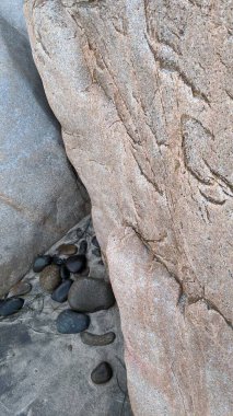 Swamis Sahili 'nin sanatsal erimiş kayaları. 50 yıl önce kıyı boyunca uzanan erozyon kontrol kayaları Swamis Resif Sörf Parkı Encinitas California 'daki dalga enerjili kaya parlatıcı ekibindeki çok renkli nehir kayalarıyla çevrili..