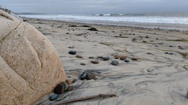 Swamis Sahili 'nin Erimiş Kayalıkları. 50 yıl önce kıyı şeridi boyunca uzanan okyanus dalgası erozyon kontrol taşları Swamis Resif Sörf Parkı Encinitas California 'daki antik nehir kayaları ve soyut heykellere benziyor..