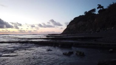 San Diego yakınlarındaki Güney Kaliforniya plaj sahneleri - Encinitas California 'daki Swamis Resif Sörf Parkı' ndaki günbatımları, sörfçüler, gelgit havuzları, dalgalar, kayalar, kum plajları ve palmiye ağaçları.