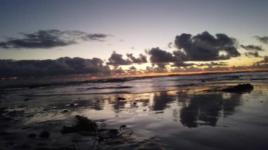 San Diego yakınlarındaki Güney Kaliforniya plaj sahneleri - Encinitas California 'daki Swamis Resif Sörf Parkı' ndaki günbatımları, sörfçüler, gelgit havuzları, dalgalar, kayalar, kum plajları ve palmiye ağaçları.