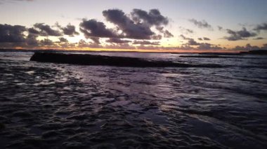 San Diego yakınlarındaki Güney Kaliforniya plaj sahneleri - Encinitas California 'daki Swamis Resif Sörf Parkı' ndaki günbatımları, sörfçüler, gelgit havuzları, dalgalar, kayalar, kum plajları ve palmiye ağaçları.