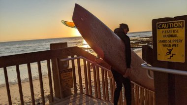 Güney Kaliforniya sahili siluetleri, sörfçüler, gelgit havuzları ve palmiye ağaçları Swamis Kayalık Sörf Parkı, Ay ışığı ve Encinitas California 'daki Cardiff plajları.