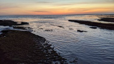 Günbatımında Güney Kaliforniya sahillerinde, eski resif gel-git havuzları, okyanus dalgaları ve Swamis Resif Parkı Encinitas California 'da alacakaranlık renkli gökyüzü.