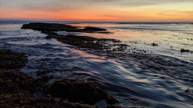 Günbatımında Güney Kaliforniya sahillerinde, eski resif gel-git havuzları, okyanus dalgaları ve Swamis Resif Parkı Encinitas California 'da alacakaranlık renkli gökyüzü.