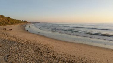San Diego yakınlarındaki Güney Kaliforniya plaj sahneleri - Encinitas California 'daki Swamis Resif Sörf Parkı' ndaki günbatımları, sörfçüler, gelgit havuzları, dalgalar, kayalar, kum plajları ve palmiye ağaçları.