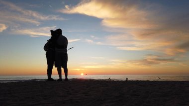 Güney Kaliforniya sahili, San Diego 'nun kuzeyi. Günbatımları, sörfçüler, gelgit havuzları, dalgalar, kayalar, kum, yosun ve palmiye ağaçları Encinitas California 'daki Swamis Resif Sörf Parkı' nda..