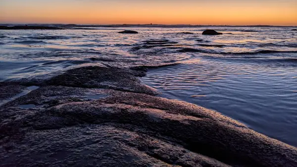 San Diego 'nun kuzeyinde Güney Kaliforniya sahilleri - Encinitas Kaliforniya' daki Swamis Resif Sörf Parkı 'nda günbatımı, sörfçüler, gelgit havuzları, dalgalar, kayalar, kum ve palmiye ağaçları.
