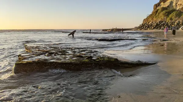 San Diego yakınlarındaki Güney Kaliforniya plajları. Günbatımları, sörfçüler, gelgit havuzları, palmiye ağaçları ve Encinitas kıyılarındaki Swamis Resif Sörf Parkı 'ndaki serin dalgalar..