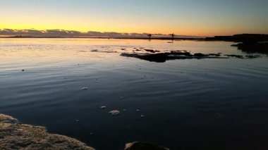 San Diego yakınlarındaki Güney Kaliforniya plaj sahneleri - Encinitas California 'daki Swamis Resif Sörf Parkı' nda günbatımı, sörfçüler, gelgit havuzları, dalgalar, kayalar, kum ve palmiye ağaçları.