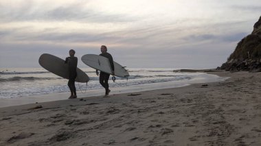 San Diego yakınlarındaki Güney Kaliforniya plajları. Encinitas kıyılarındaki Swamis Resif Sörf Parkı 'nda gün batımları, sörfçüler, gelgit havuzları ve palmiye ağaçları.