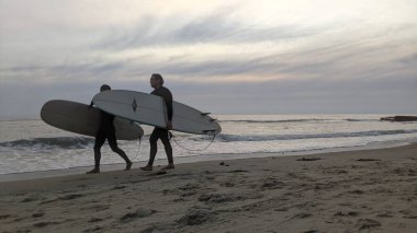 San Diego yakınlarındaki Güney Kaliforniya plajları. Encinitas kıyılarındaki Swamis Resif Sörf Parkı 'nda gün batımları, sörfçüler, gelgit havuzları ve palmiye ağaçları.