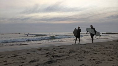 San Diego yakınlarındaki Güney Kaliforniya plajları. Encinitas kıyılarındaki Swamis Resif Sörf Parkı 'nda gün batımları, sörfçüler, gelgit havuzları ve palmiye ağaçları.