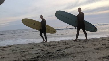 San Diego yakınlarındaki Güney Kaliforniya plajları. Encinitas kıyılarındaki Swamis Resif Sörf Parkı 'nda gün batımları, sörfçüler, gelgit havuzları ve palmiye ağaçları.